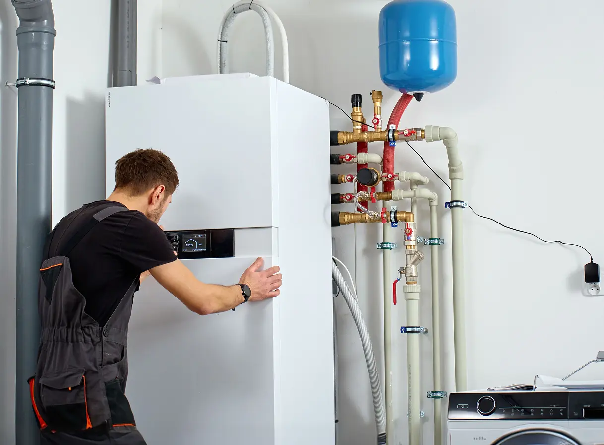 Servisný technik inštaluje alebo kontroluje moderné tepelné čerpadlo v technickej miestnosti